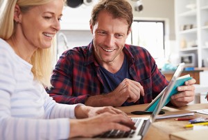 Smiling couple going over finances on a laptop