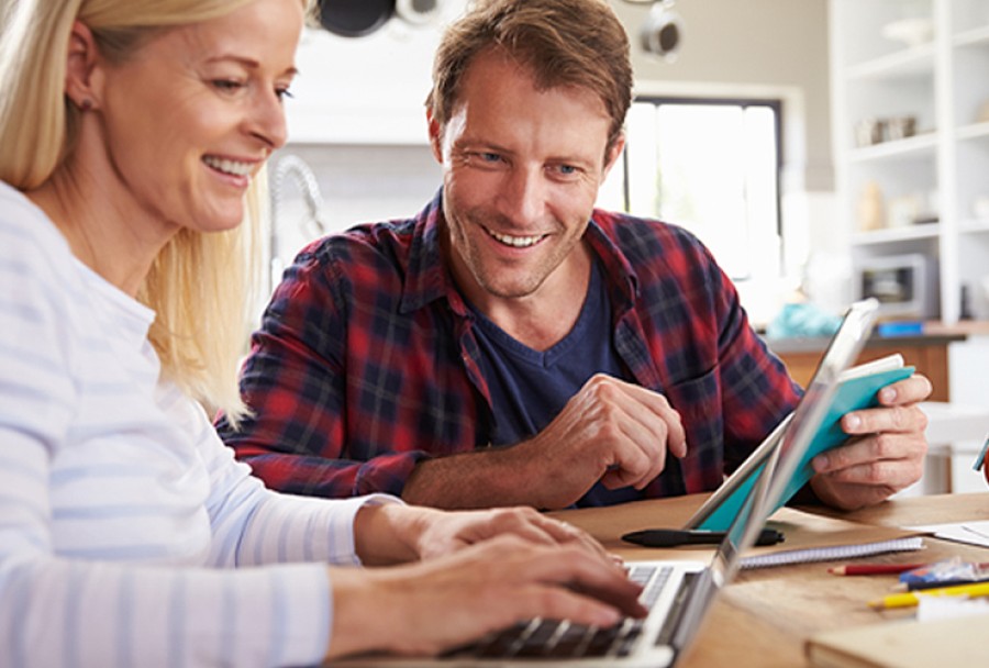 Smiling couple going over finances on a laptop