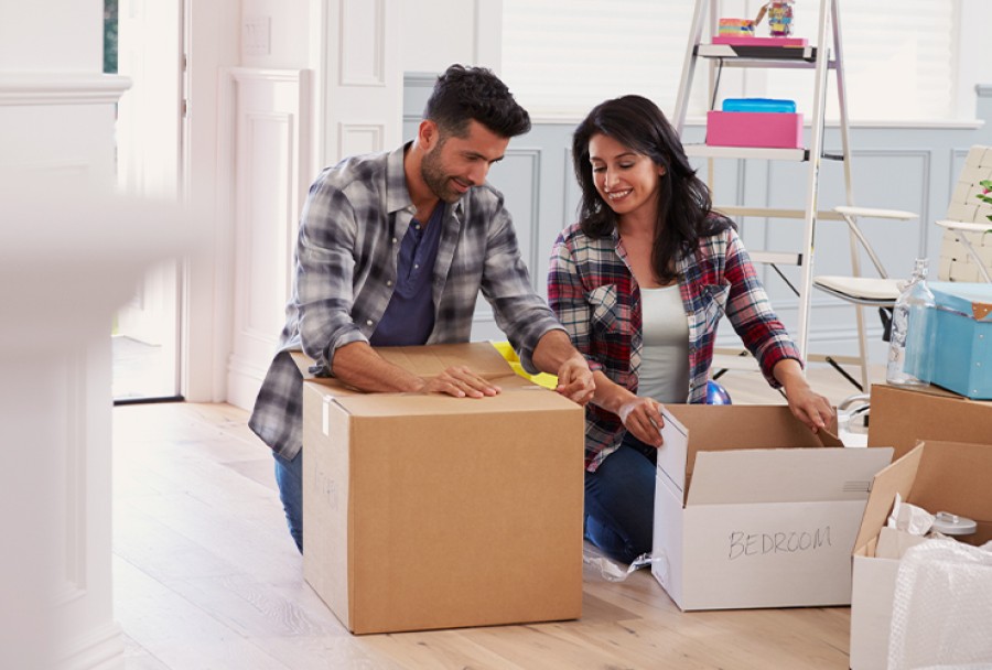 Smiling couple unpacking in their new home