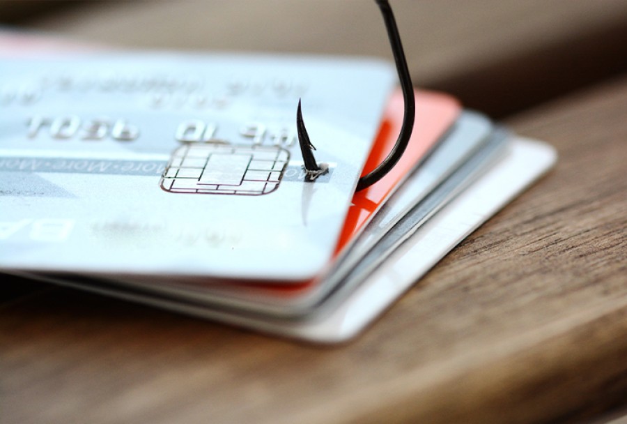 Stack of credit cards with a fishing hook attached