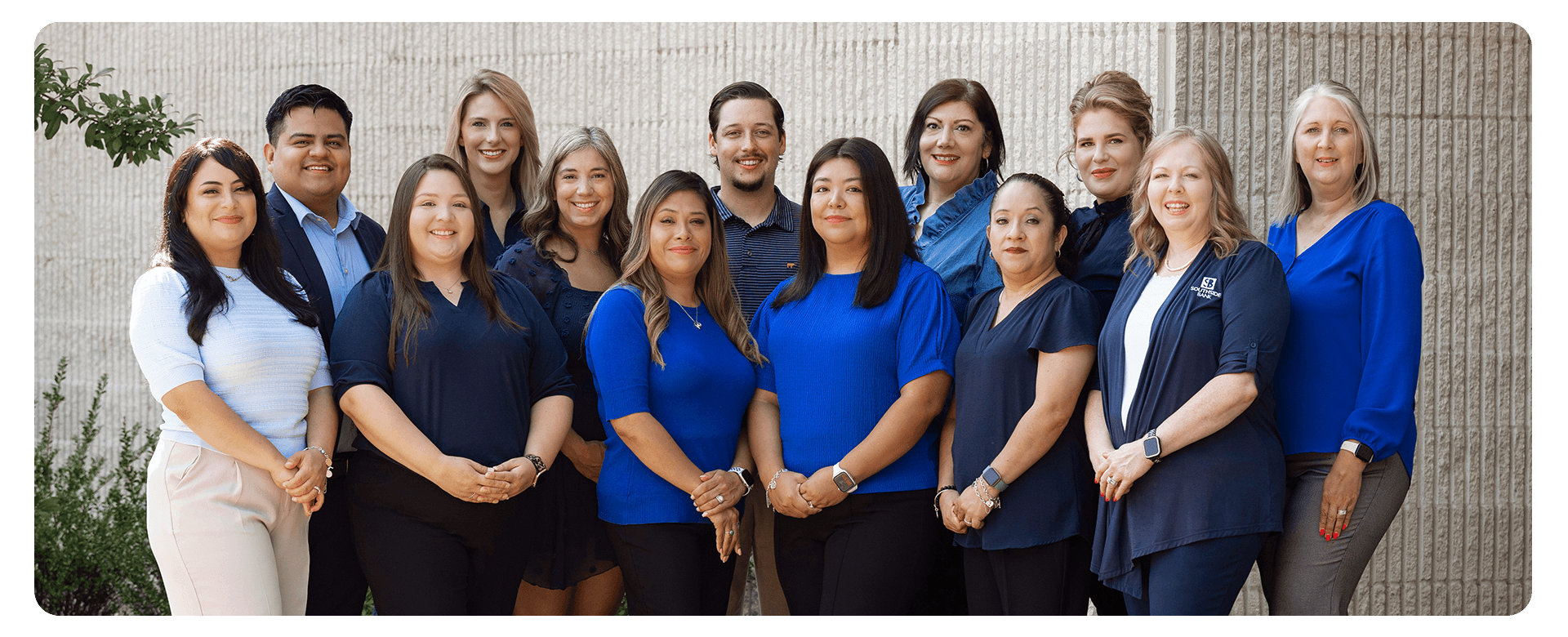 group photo of smiling employees outdoors