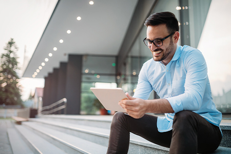 Man smiling while looking at ipad